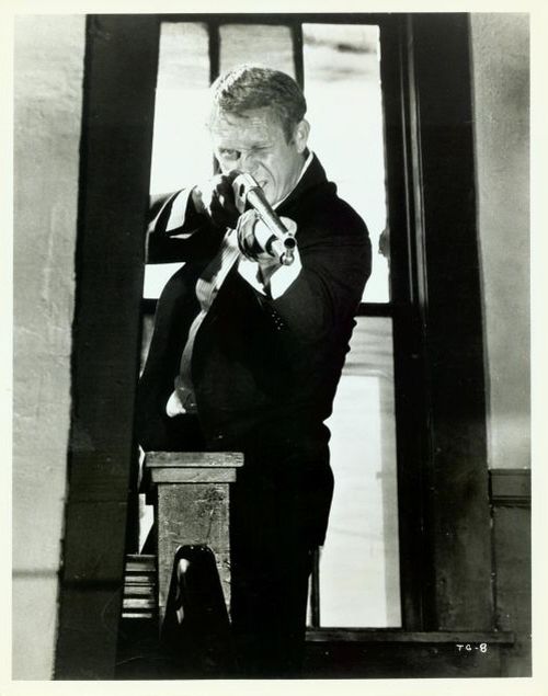 Steve McQueen (as Doc McCoy) firing shotgun.